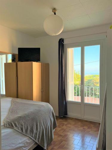 une chambre avec un lit et une porte coulissante en verre dans l'établissement Appartement à Erbalunga face à la mer, à Brando