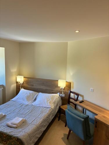 a bedroom with a bed and a desk and a chair at Auberge de Saugras in Argelliers
