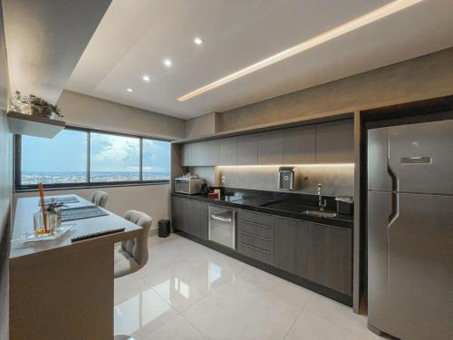 a kitchen with a stainless steel refrigerator and a counter at Modernidade e Luxo no 30º Andar in Campo Grande