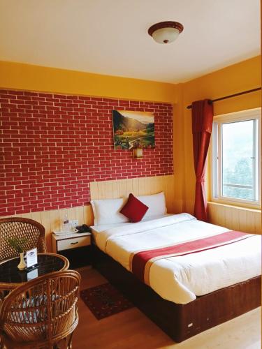 a bedroom with a bed and a red brick wall at Paradise Villa in Nagarkot