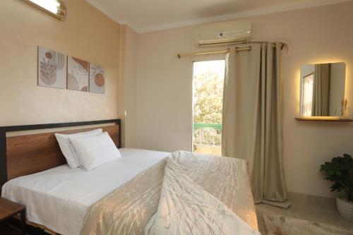 ein Schlafzimmer mit einem Bett und einem Fenster in der Unterkunft Darya's Studios - Stylish &Comfy Apartments, New Cairo in Kairo