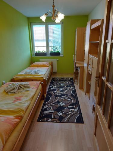 a small room with two beds and a rug at Apartmán Jantoľák in Zuberec