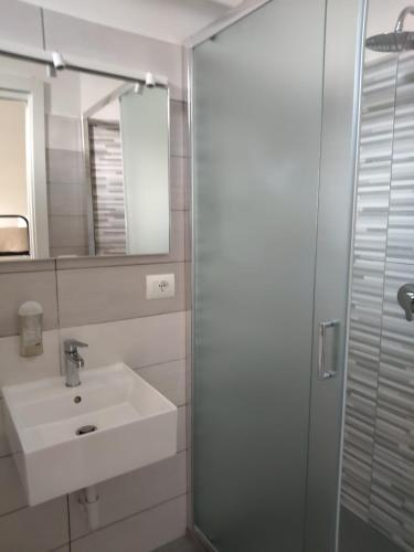 a bathroom with a sink and a shower with a mirror at Hotel Garisenda B&B - in Centro a Riccione - in Riccione