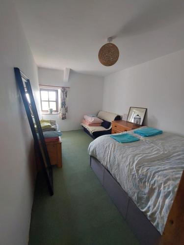 a bedroom with a bed and a desk and a couch at Rural Historic Farmhouse - A Peaceful Escape in West Down