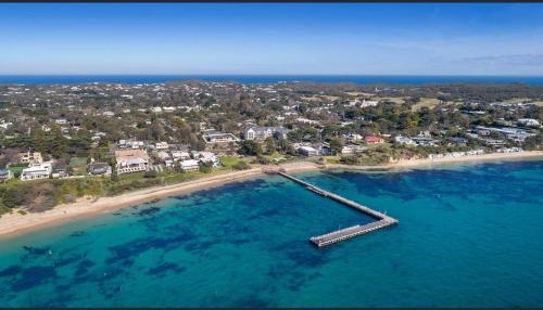 an aerial view of a beach with a dock in the water at The Ultimate Getaway in Portsea