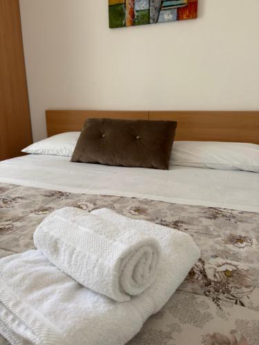 a bed with two white towels on it at Costa House in Cefalù