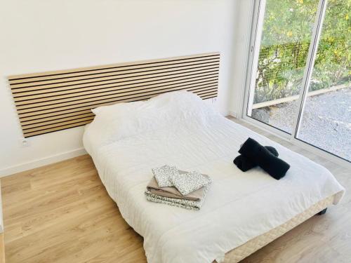 a bedroom with a white bed with two pillows and a window at Villa T4, île de la marina, parking in Cap d'Agde