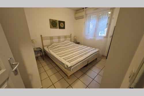 une chambre avec un lit dans une pièce avec une fenêtre dans l'établissement Joli T2 dans résidence de vacances - Sierra Madre 202, à Canet