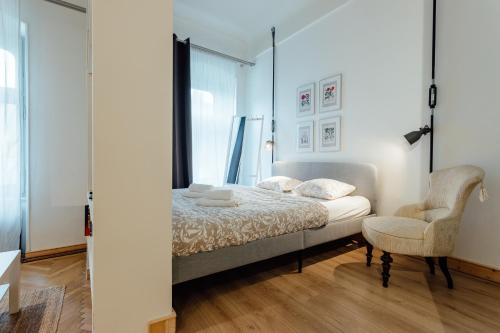 a bedroom with a bed and a chair at Apartmán CityPulse in Banská Štiavnica