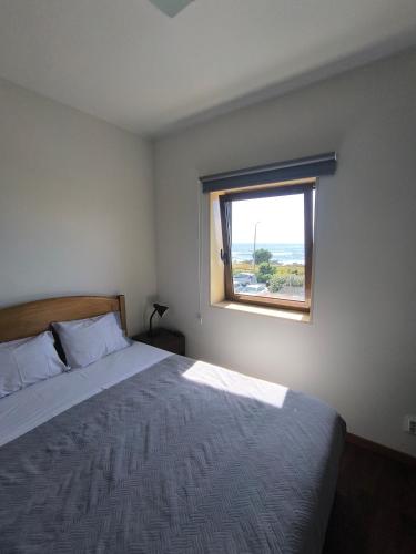 a bedroom with a large bed and a window at Casa Velha in Matosinhos