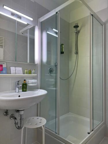 a bathroom with a sink and a shower at Vitalhotel Sonneck in Bad Wörishofen