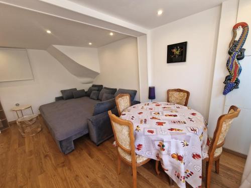 une salle à manger avec une table et un canapé dans l'établissement Studio Drancy avec Jardin 45 m2, à Drancy