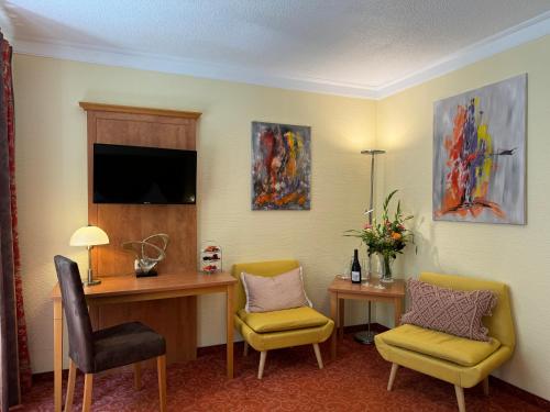a hotel room with a desk and two chairs at Vitalhotel Sonneck in Bad Wörishofen