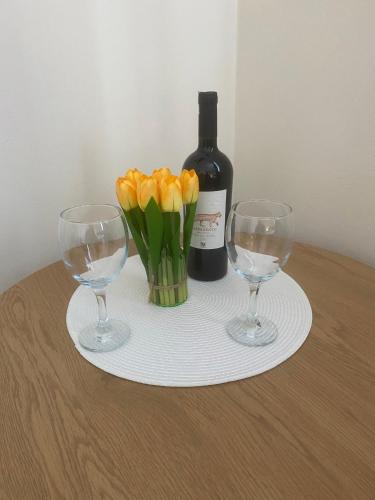 a table with two wine glasses and a bottle of wine at Apartament Mączyńskiego 4 in Jarosław