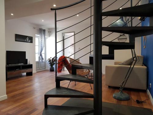 - un escalier en colimaçon dans le salon doté d'un canapé dans l'établissement Appartement L'Armande, à Arles