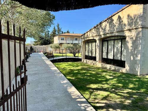 a building with a fence and a grass yard at Mas d'Andiol in Plan-dʼOrgon