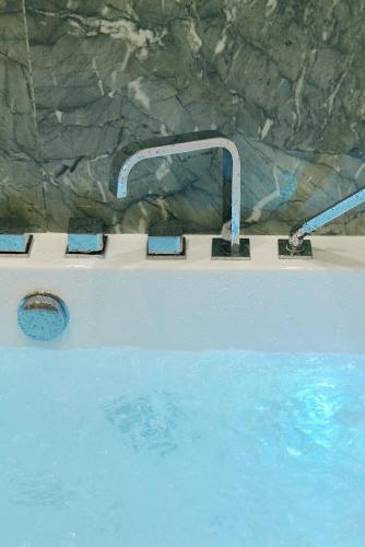 - une baignoire avec un robinet dans la piscine dans l'établissement Lavie Maison Central AC Hot Tub, à Paris