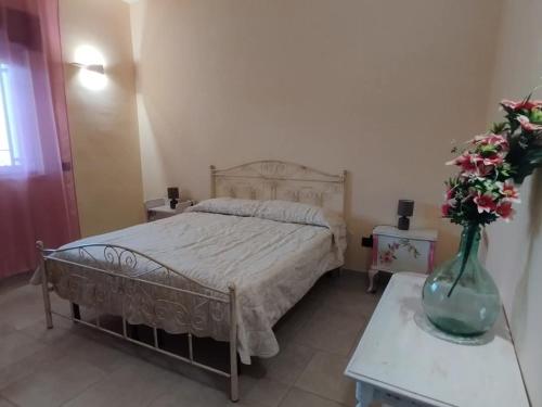 sypialnia z łóżkiem i wazonem kwiatów na stole w obiekcie Villa Grazia w mieście San Pietro in Bevagna