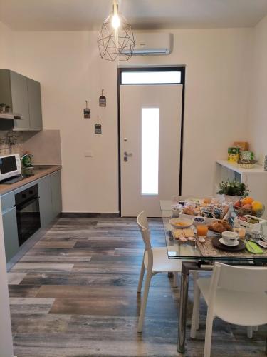 una cucina con tavolo in vetro con cibo sopra di B&B Aterno a Montesilvano