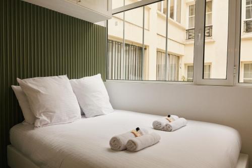 une chambre avec un lit avec des serviettes dessus dans l'établissement Lavie Maison Central AC Hot Tub, à Paris