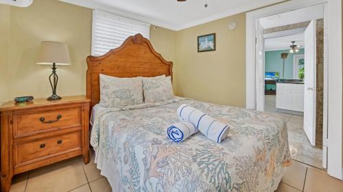 una camera da letto con un letto con testiera in legno di Barbuda Suite by Last Key Realty a Key West
