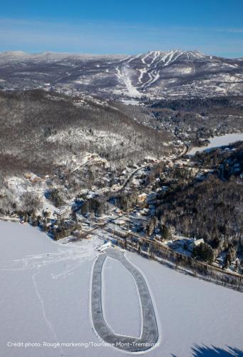 an aerial view of a snow covered city with a road at Bondurant Village Center Spectacular Condo in Mont-Tremblant