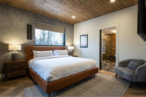 a bedroom with a large bed and a chair at NEW! Chalet Forena 4 Bedrooms in La Conception
