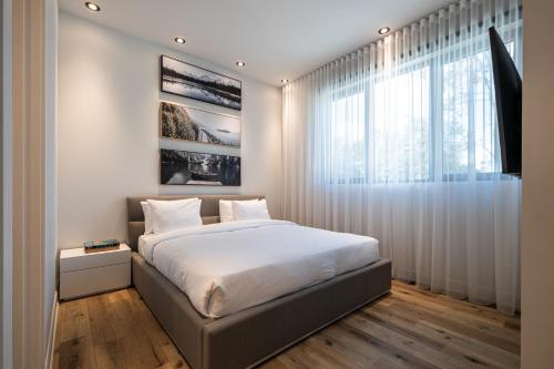 a bedroom with a bed and a large window at NEW! Chalet Aurora 5 Bedrooms Hot tub Outdoor Pool in La Conception