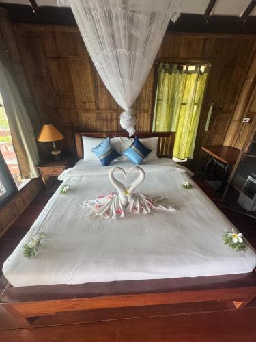 a bed with a heart made out of flowers on it at Drifters Anchor in Ban Map Khangkhao