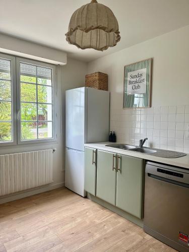 une cuisine avec un réfrigérateur blanc et un évier dans l'établissement Bois bas cottage - Baden bord de mer proche Vannes, à Baden