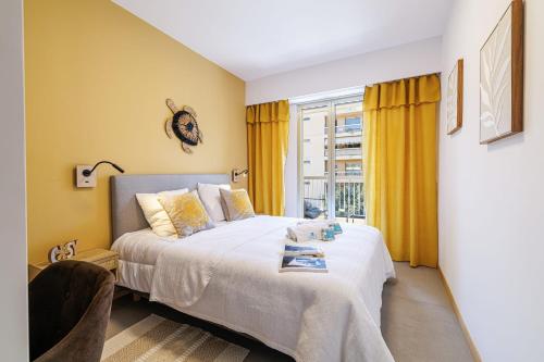 a bedroom with a bed with yellow walls and a window at GAIRAUT - 5 rooms - Terrass in Nice