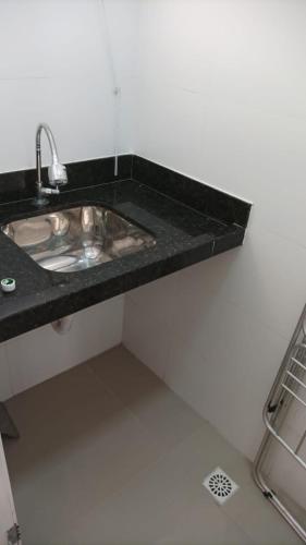 a bathroom sink with a black counter top at Casa Lelis - Descanso para a família e seu pet, pertinho do mar - praia Guarujá - SP in Guarujá
