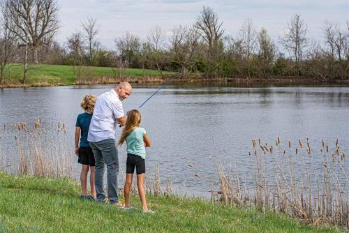 a man and two children fishing in a lake at Heated Pool, Hot Tub, Mini Golf, Theater-Sleeps 28 in Frankfort
