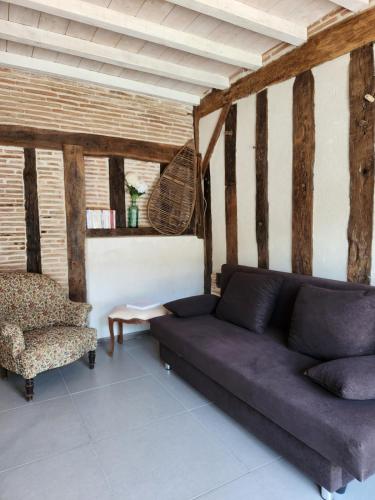 a living room with a couch and a chair at Gîte sous les pins La grange à deux in Giscos
