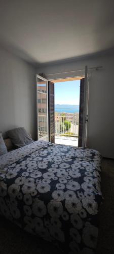 une chambre avec un grand lit et une grande fenêtre dans l'établissement F2 Entrée de la ville Vue Mer, à Ajaccio