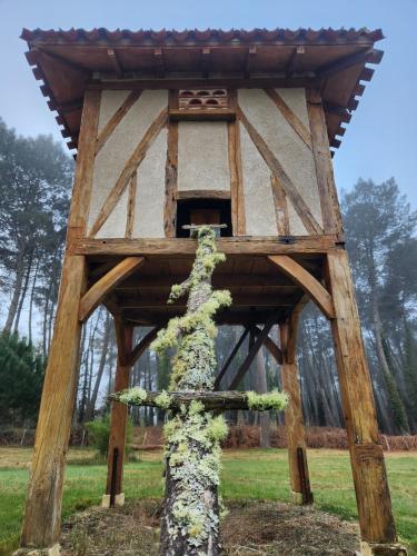 a tree house with a tree growing out of it at Gîte sous les pins La grange à deux in Giscos