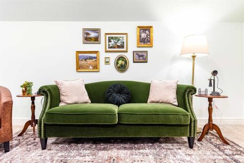 a green couch in a living room with two tables at Heated Pool, Hot Tub, Mini Golf, Theater-Sleeps 28 in Frankfort
