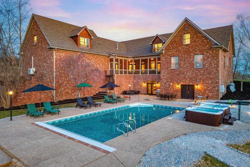 a large brick house with a swimming pool in front of it at Heated Pool, Hot Tub, Mini Golf, Theater-Sleeps 28 in Frankfort