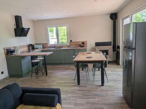 une cuisine avec une table et un réfrigérateur dans l'établissement Gîte des Écuries de Rougemare, à Pierrefiques