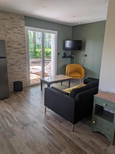 un salon avec un canapé et une table dans l'établissement Gîte des Écuries de Rougemare, à Pierrefiques