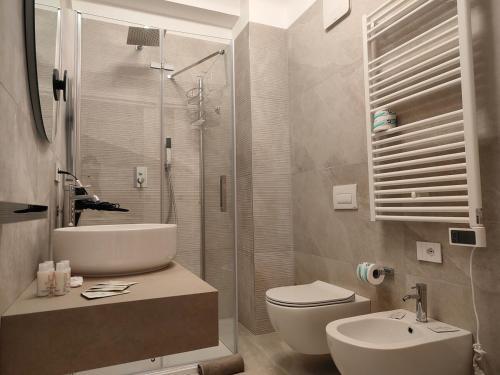 a bathroom with a sink and a toilet and a shower at CconfortHotels Suite 104 in Bari