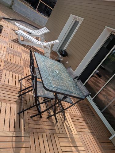 une table et des chaises sur une terrasse en bois dans l'établissement Gîte des Écuries de Rougemare, à Pierrefiques