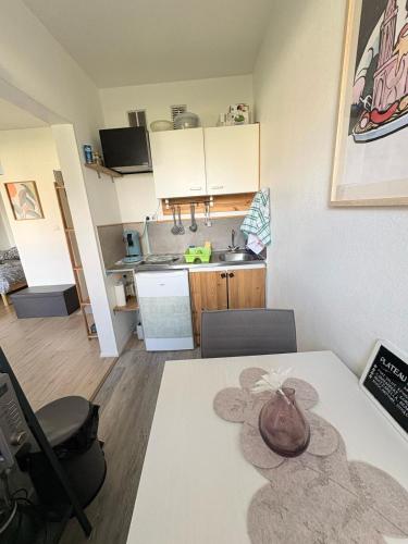 une cuisine et une salle à manger avec une table et une cuisine gmaxwell gmaxwell dans l'établissement Studio RDC calme avec parking fermé près autoroute et tram C, à Mulhouse