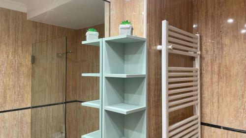 a bathroom with white shelves next to a shower at Douro Villa in Porto