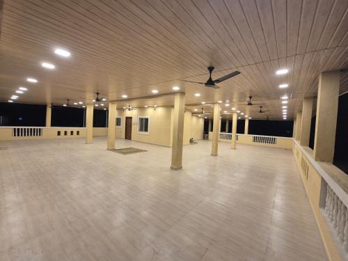 a large room with a ceiling with columns and a ceiling fan at Prashant Homestay Alibag in Alibaug