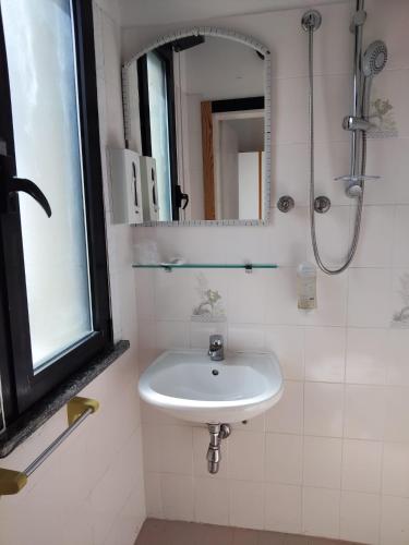 a white bathroom with a sink and a mirror at Hotel Garisenda B&B - in Centro a Riccione - in Riccione