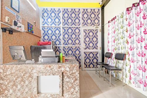 Una oficina con un mostrador de recepción con azulejos azules y blancos. en Hotel O Mo Kudia, en Brahmapur