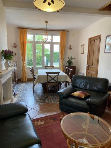 un salon avec un canapé et une table dans l'établissement Mer et Campagne, maison entourée d'un jardin privé, à Quend