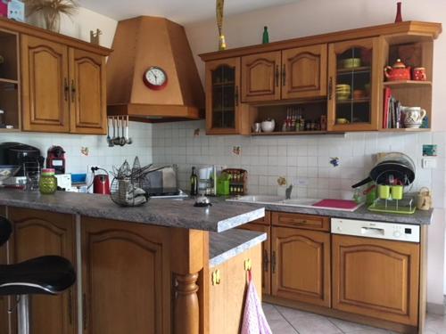 une cuisine avec des armoires en bois et un comptoir dans l'établissement Gîte aux papillons, à La Garde