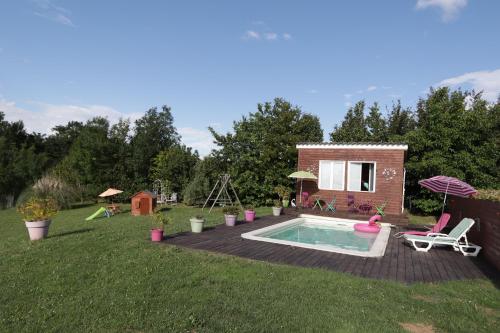une cour arrière avec une piscine et une maison dans l'établissement Gîte aux papillons, à La Garde
